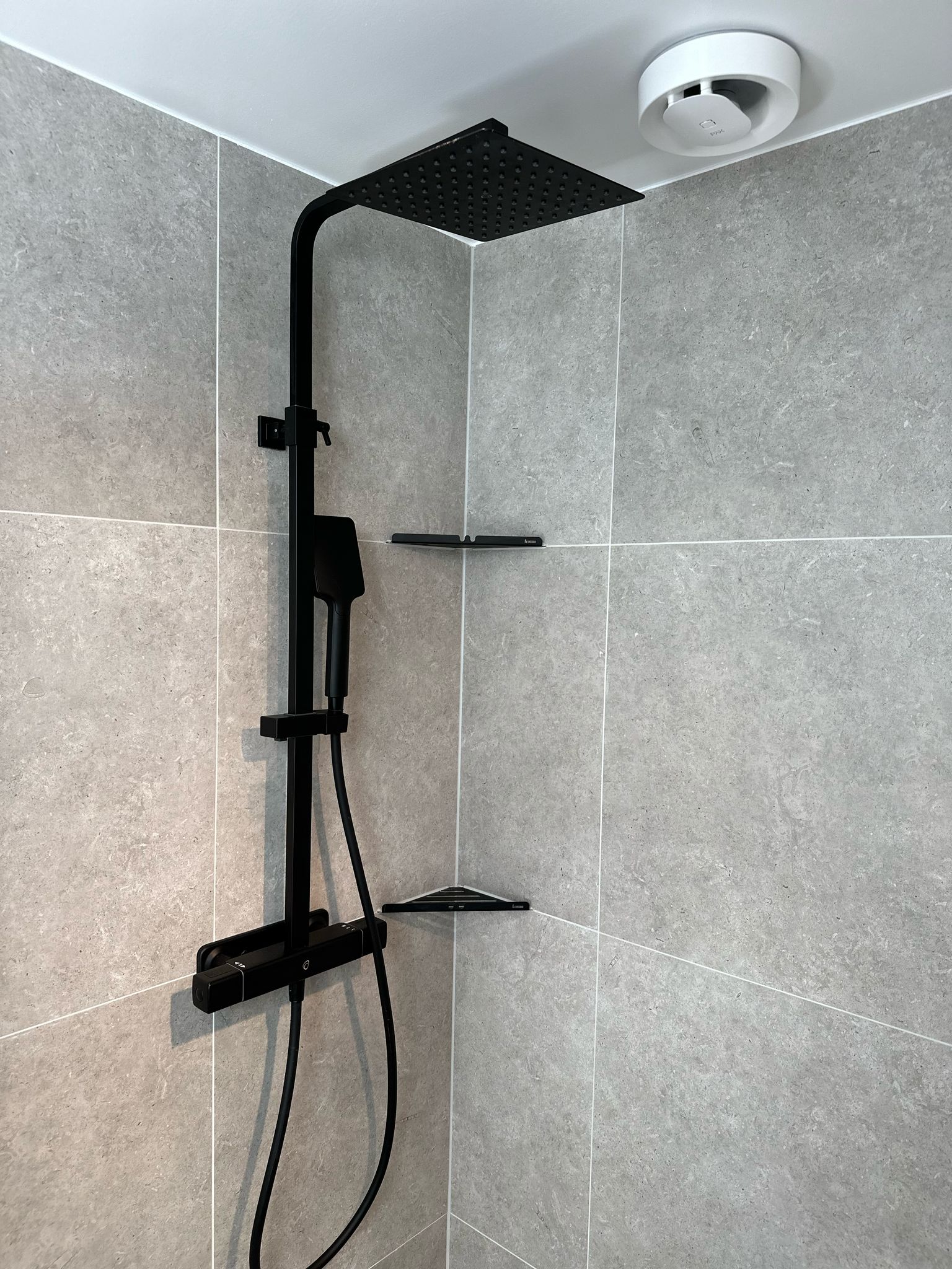 Badrum med 60x60 klinker och svarta detaljer3